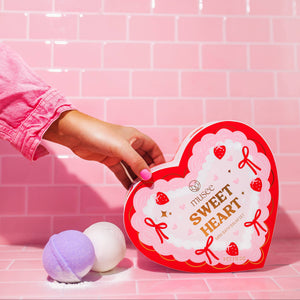 Heart-shaped box labeled 'Sweet Heart' with bath bombs on a pink tiled background
