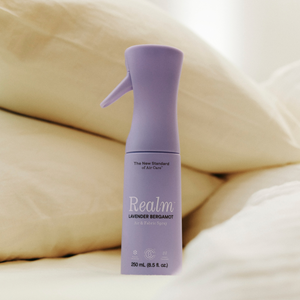 Purple bottle of Realm lavender bergamot air freshener on beige fabric background