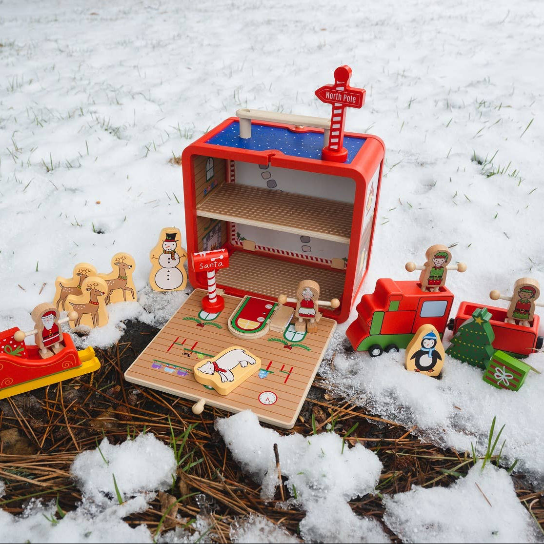 Toy set with a red playhouse and various figures on a snowy ground