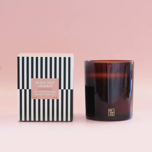 Candle and its packaging on a pink background