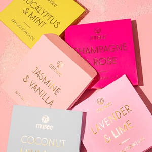 Collection of musèe bath salt soaks with various scents on a pink background