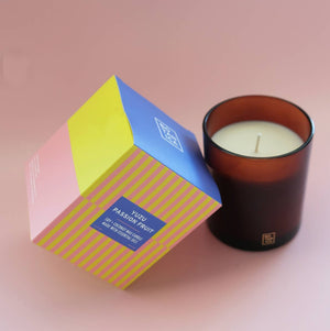 Candle with a colorful box on a pink background