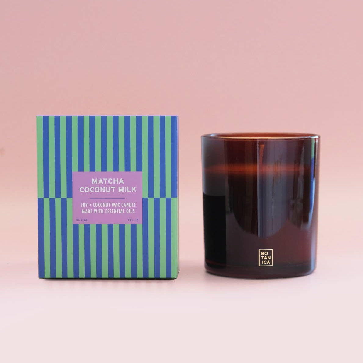 Candle with striped packaging on a pink background