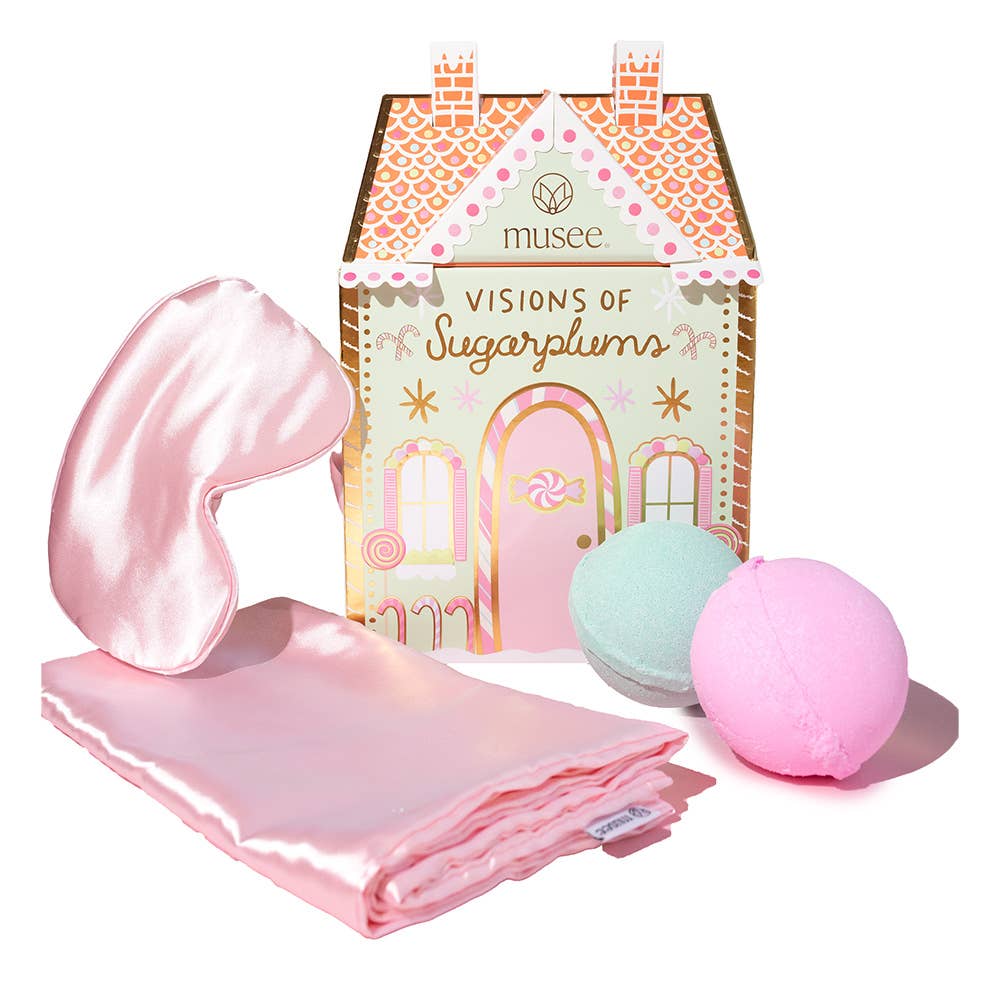 Pink satin eye mask, bath bombs, and 'Visions of Sugarplums' packaging on a white background