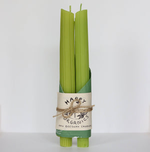 Set of green candles with a 'Happy Organics' label on a white background