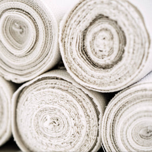 Close-up of rolled-up beige fabric on a white background