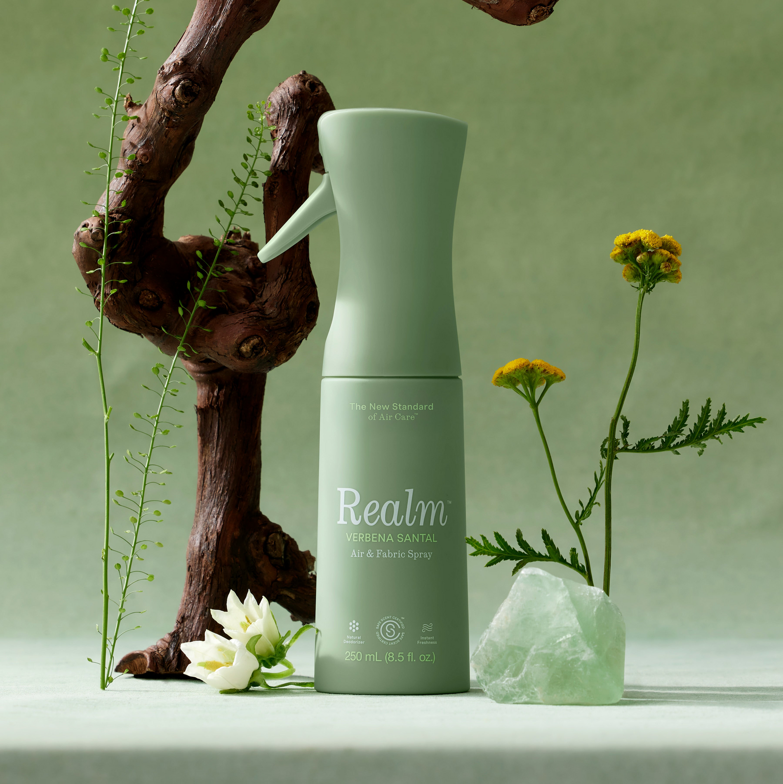 Green spray bottle labeled 'Realm' on a green background