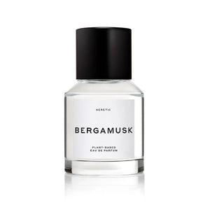 A bottle of Bergamusk perfume, surrounded by limes and greenery. 
