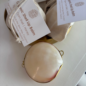 Organic shell lip balm with packaging and labels on a white surface