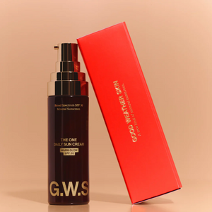 Black sun cream bottle with red box on a beige background