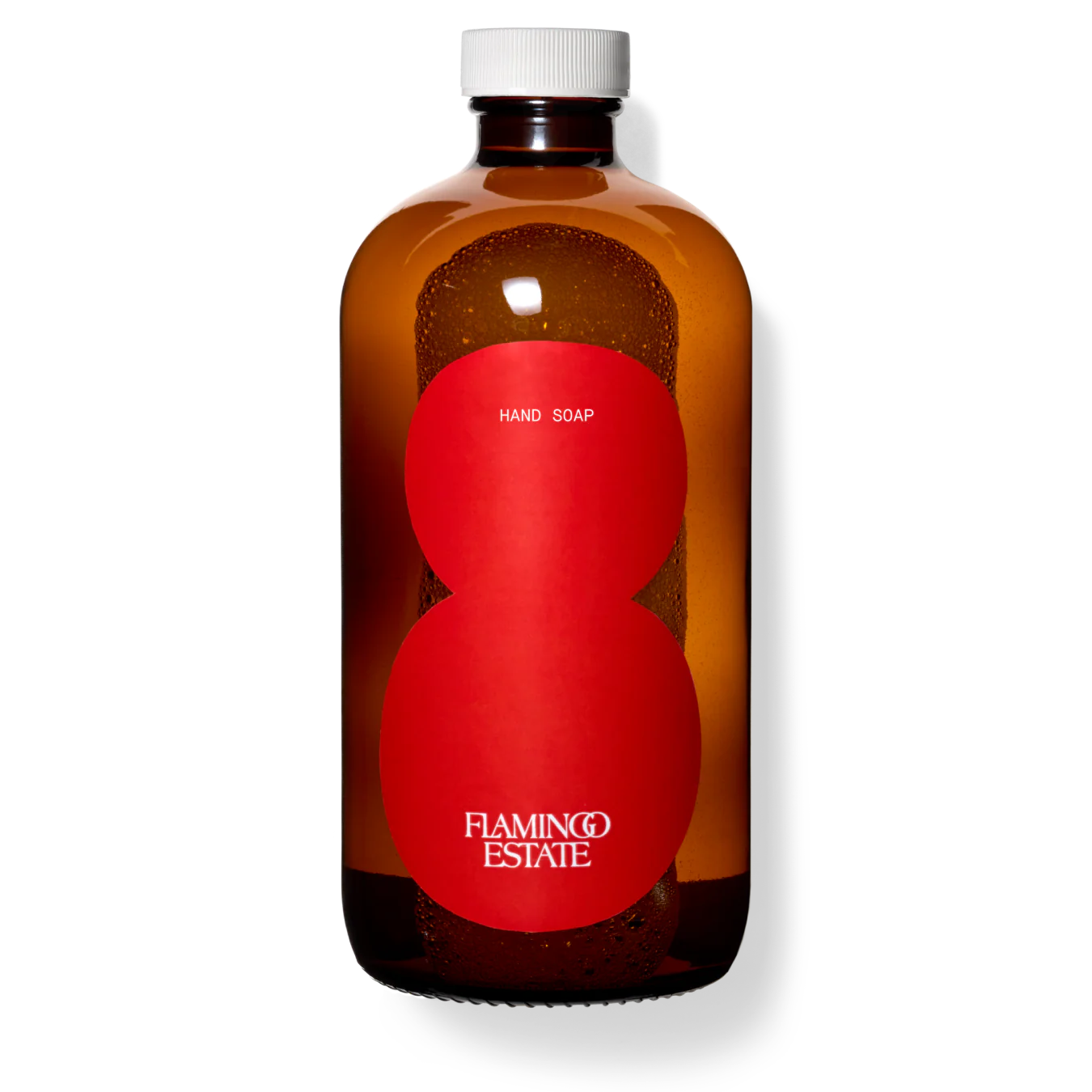A brown glass bottle of Flamingo Estate tomato hand soap with a white cap