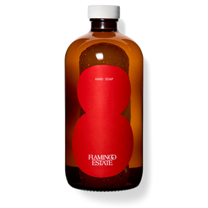 A brown glass bottle of Flamingo Estate tomato hand soap with a white cap