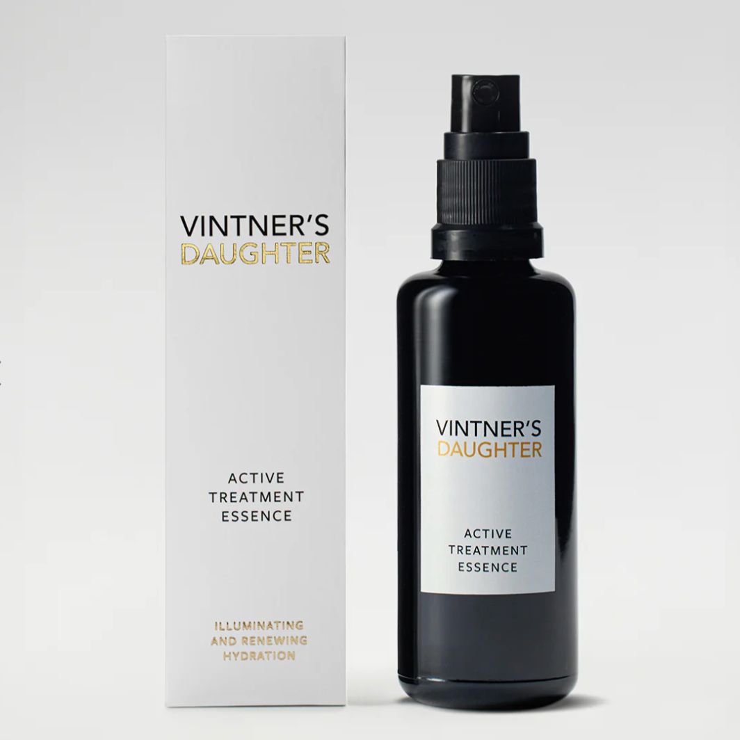 A black spray bottle labeled 'Vintner's Daughter Active Treatment Essence' with a badge stating '8-in-1 Facial in a Bottle'.