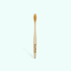 Bamboo toothbrush with 'RiseWell' branding on a white background