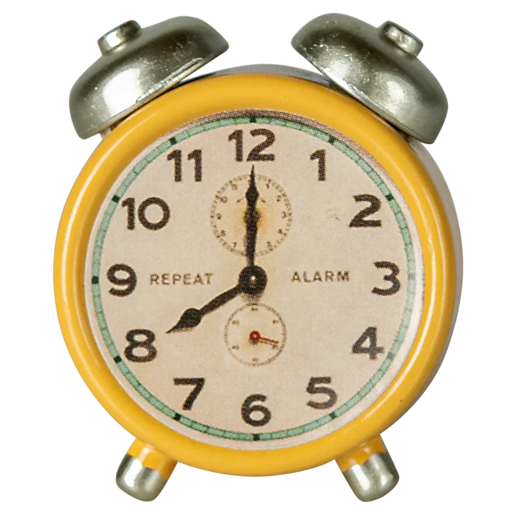 A small yellow metal alarm clock with black hands and numbers, and silver accents.