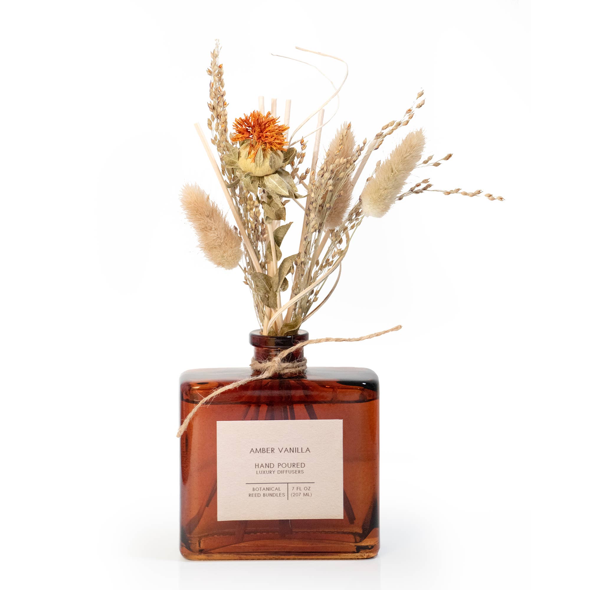 Amber glass bottle with dried flowers on a white background