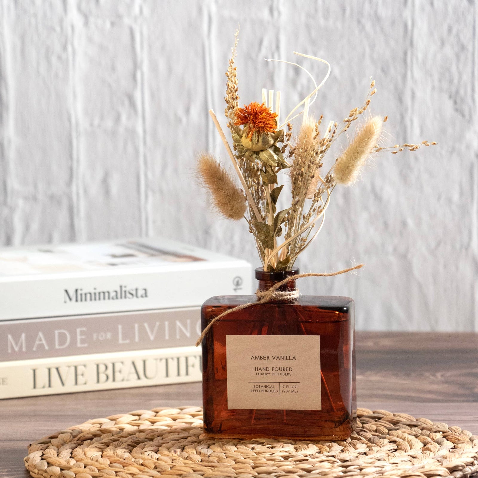 Amber glass bottle with dried flowers on a white background