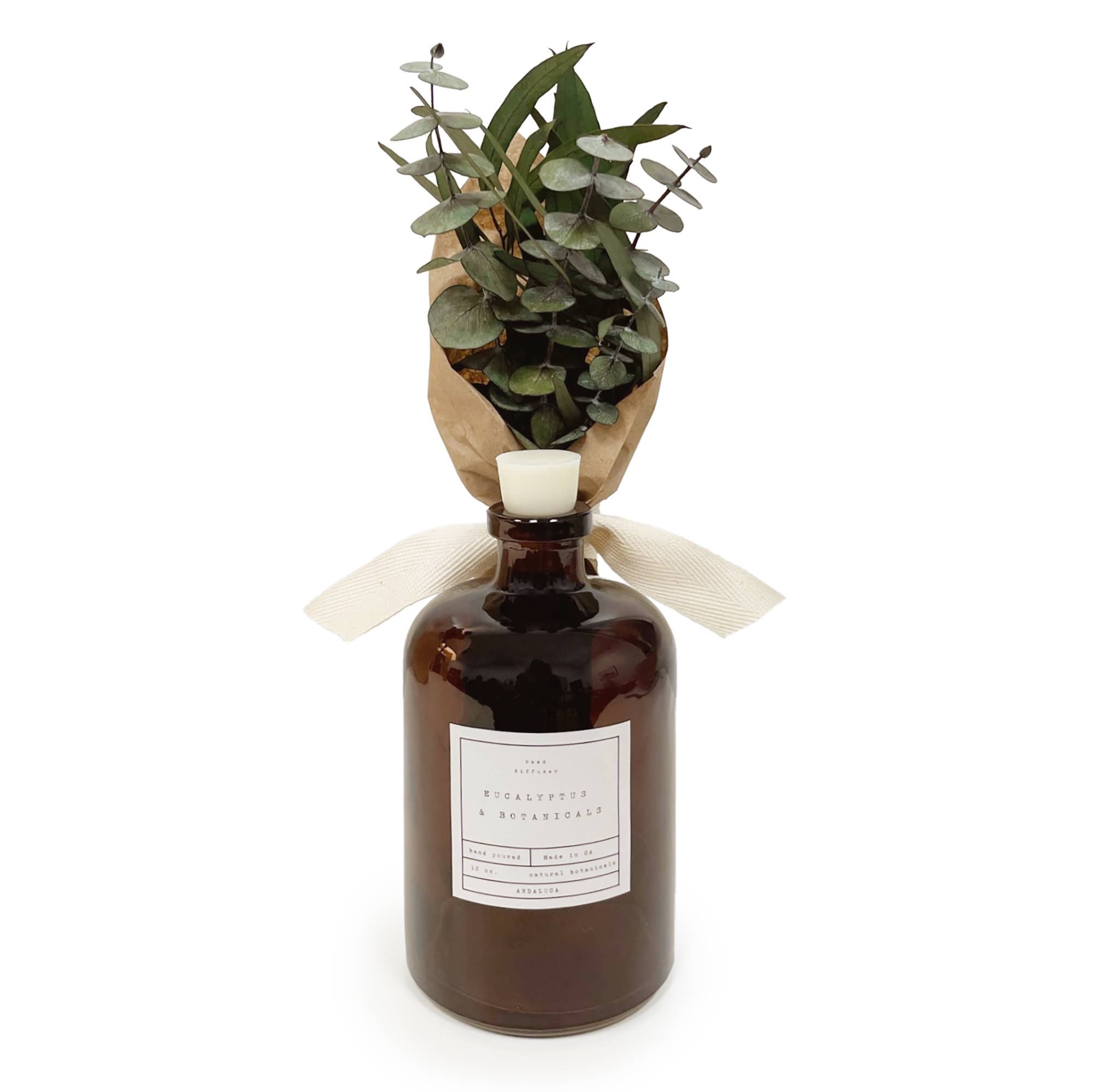 Brown bottle with eucalyptus leaves on a white background