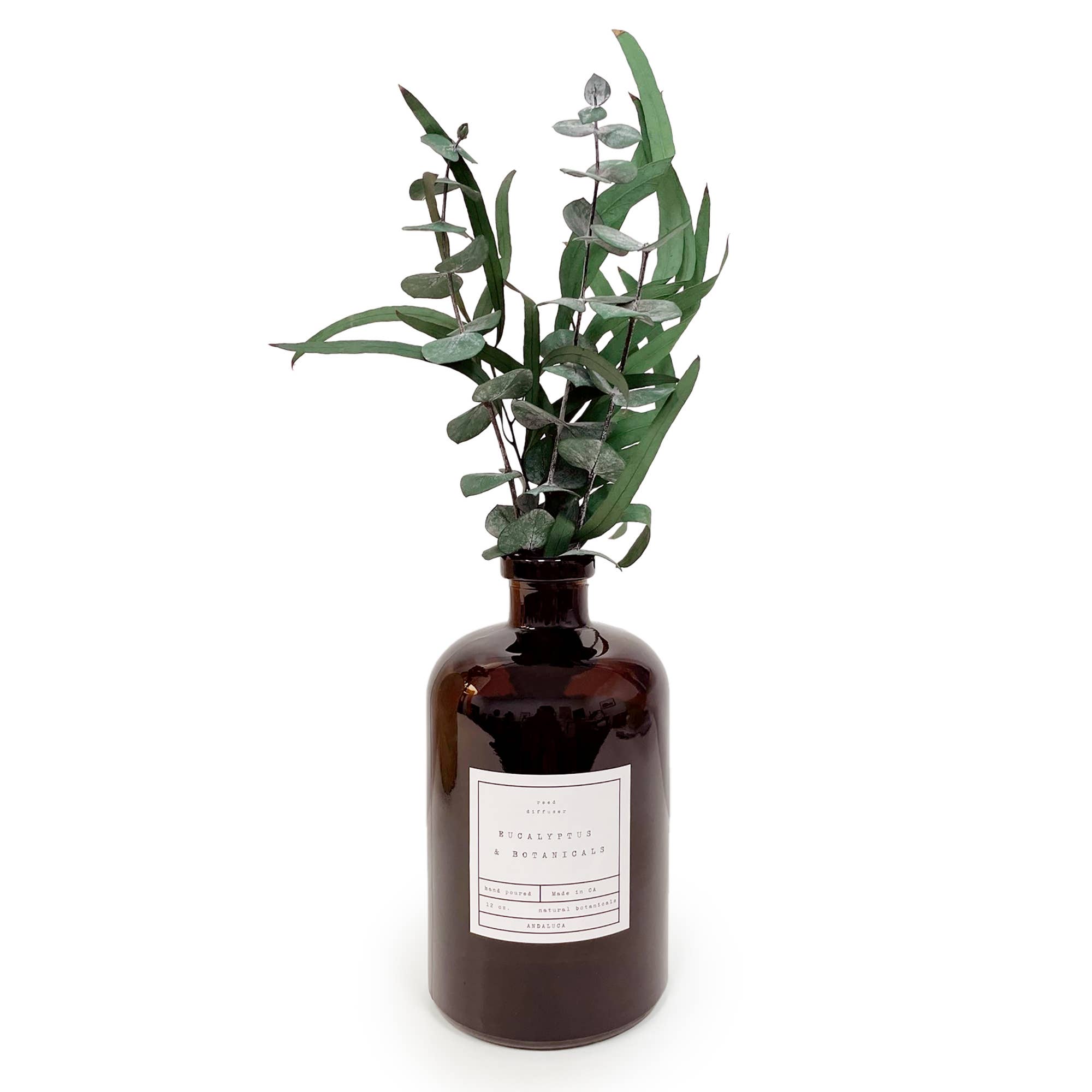 Brown bottle with eucalyptus leaves on a white background