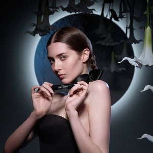 Woman holding a product with a dark, artistic background