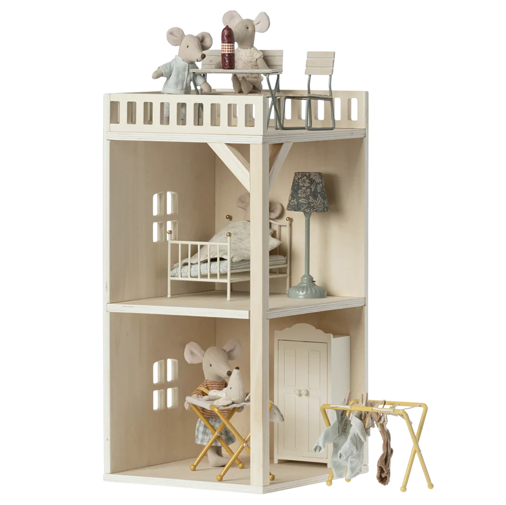 A toy mouse hole farmhouse annex with multiple floors, furniture, and a terrace, made of beige wood.