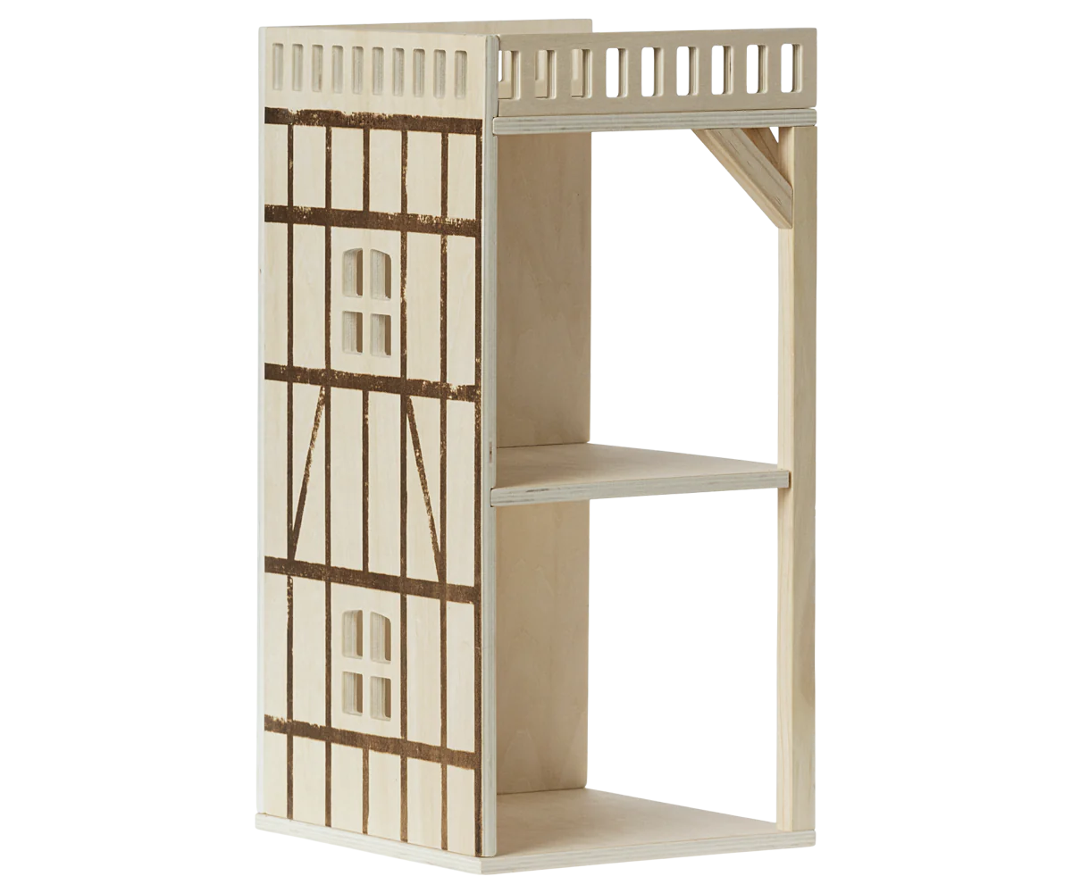 Wooden dollhouse with a ladder on a white background