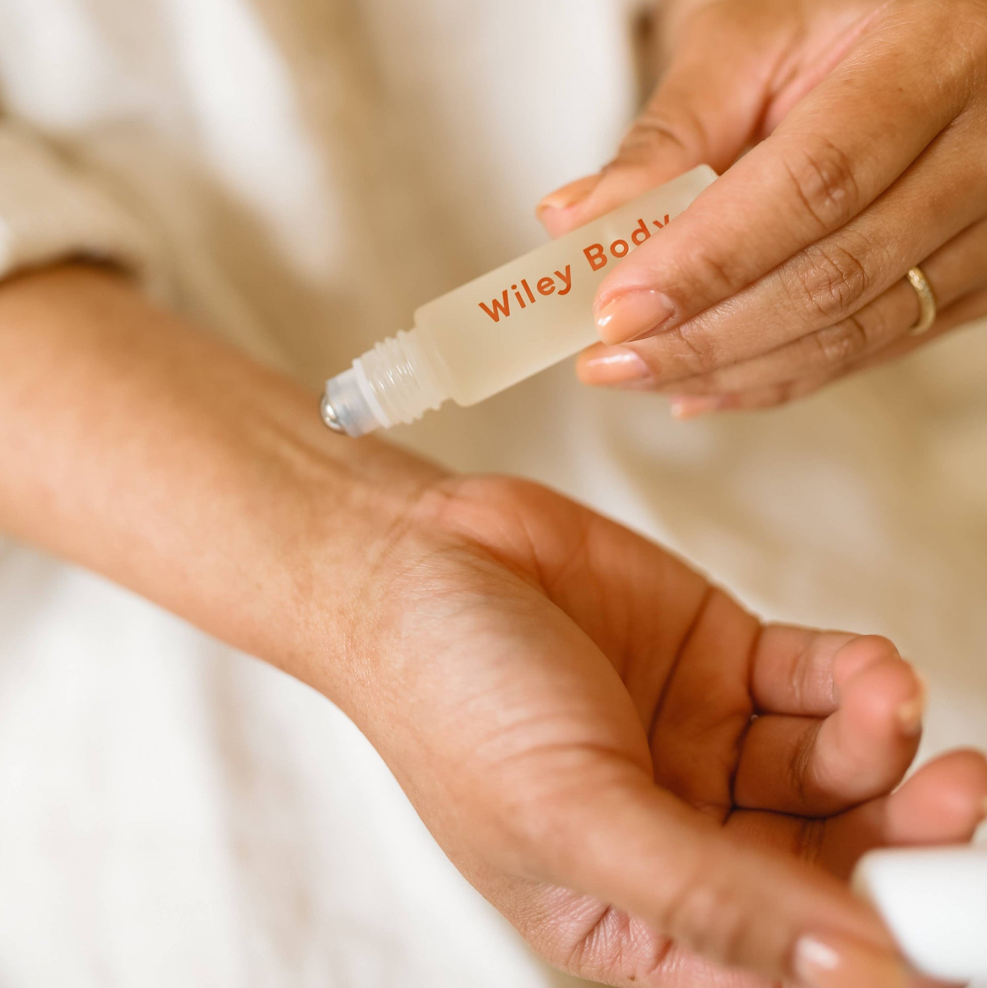 A small bottle of Wiley Body relax roller oil with a label that reads 'For my body', positioned on a textured surface.