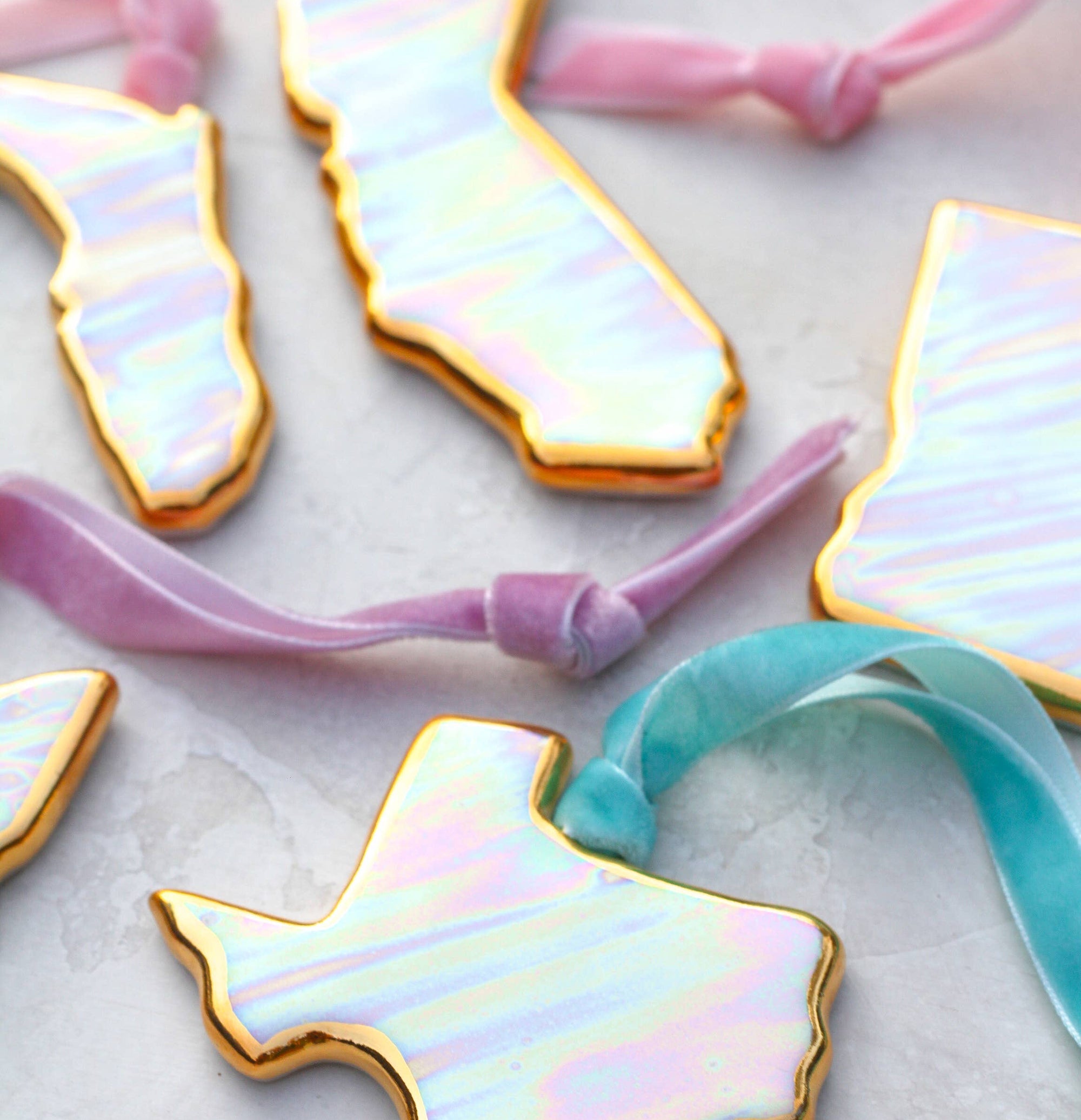 Iridescent state-shaped hair ties on a light background