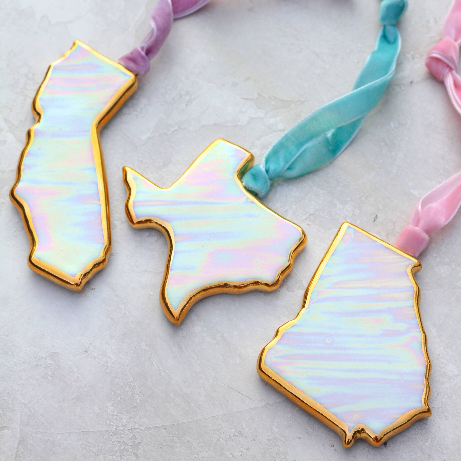 Iridescent state-shaped hair ties on a light background