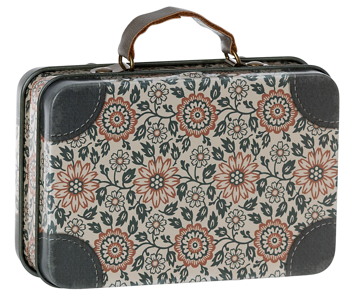 A small metal suitcase with a floral pattern and leather-like handles.