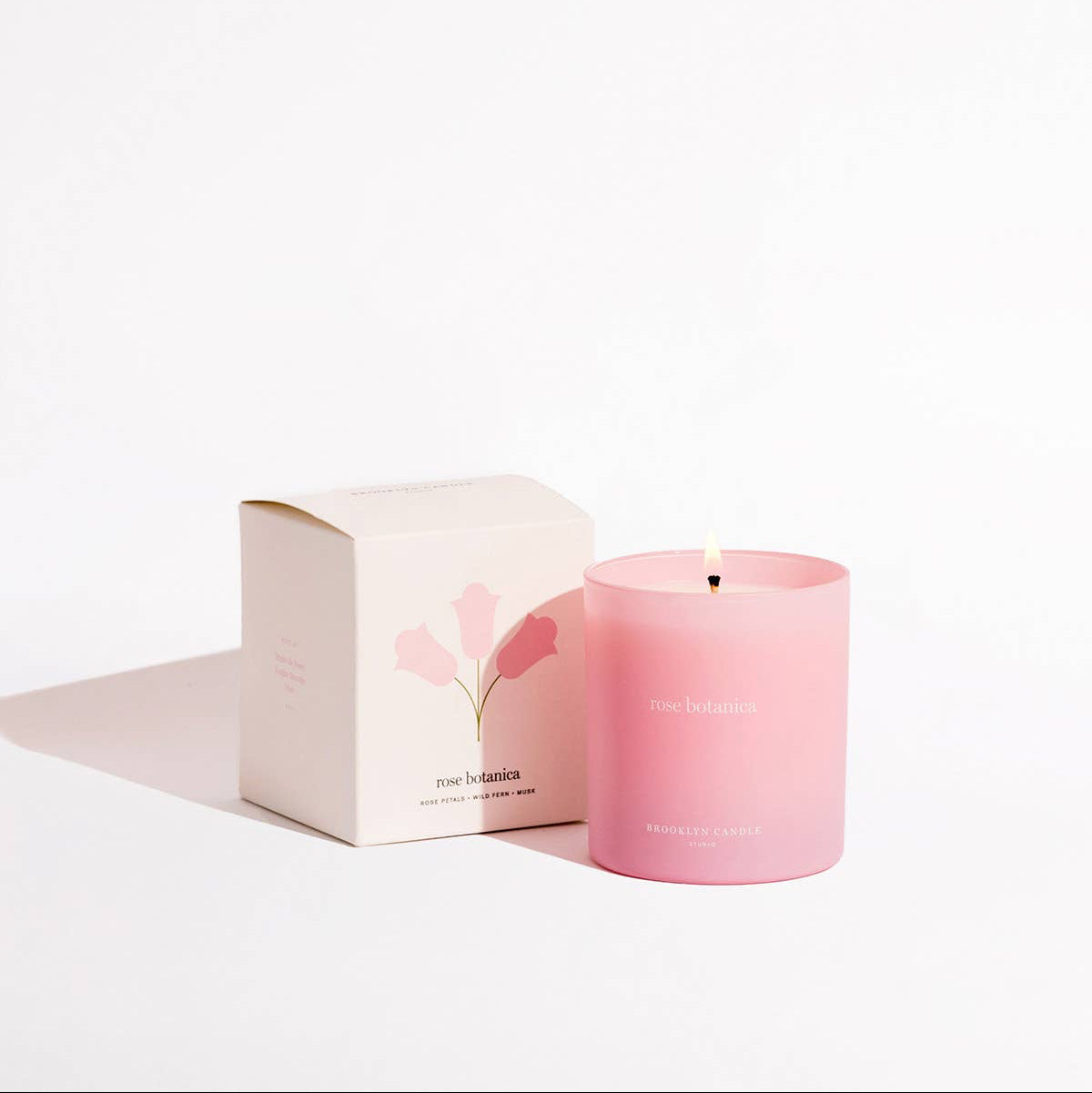 Pink candle with matching box on a white background