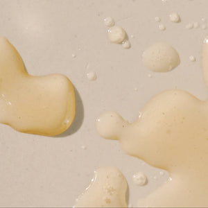 Close-up of beige liquid droplets on a light background