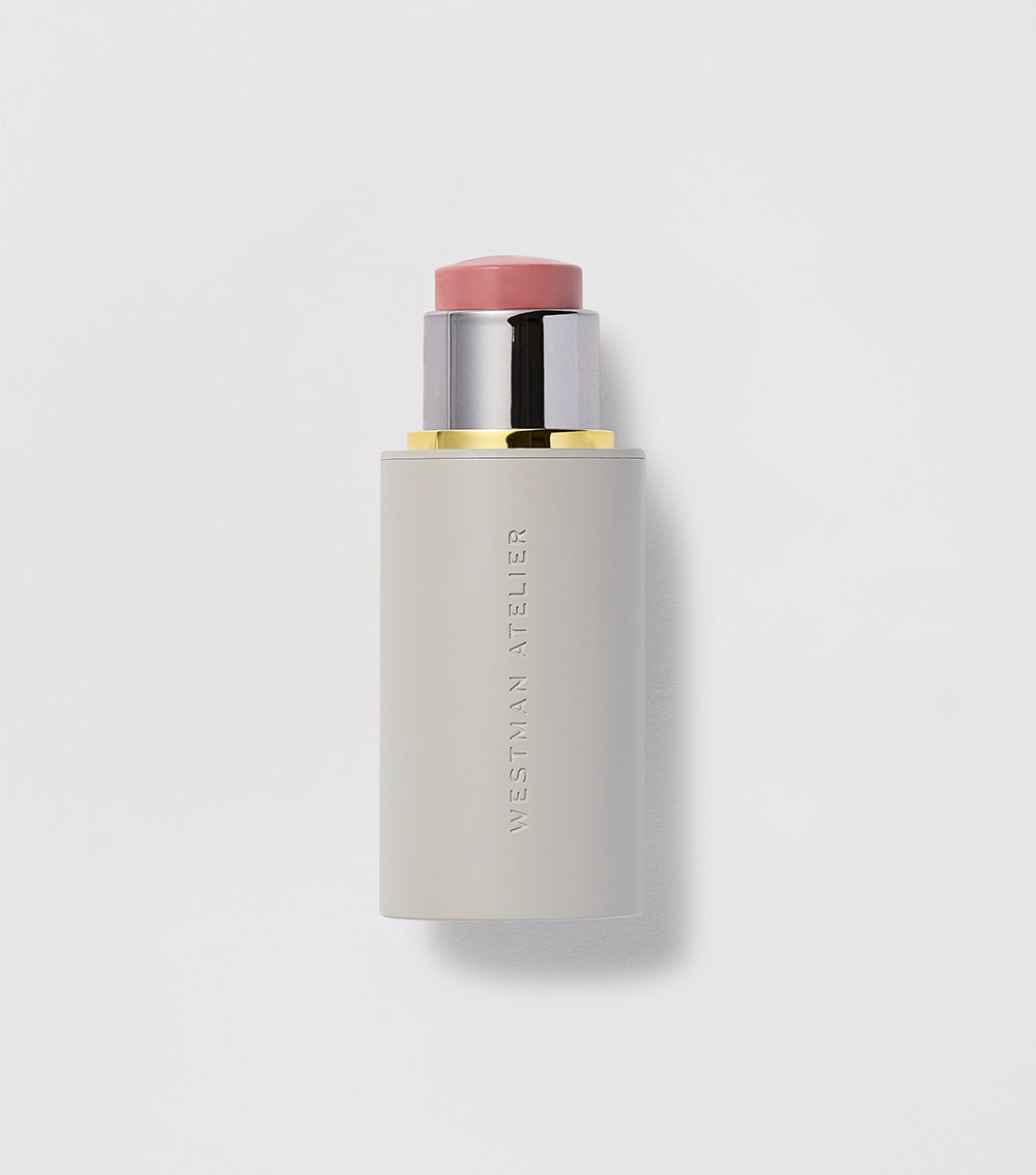 A Baby Cheeks Blush Stick with the cap off, showing a light pink color.