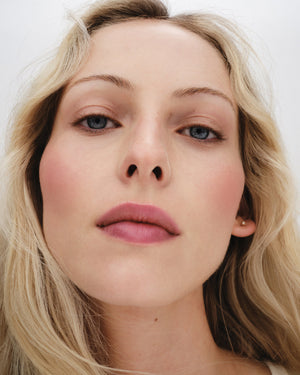 Close-up of a person with blonde hair and blue eyes on a white background