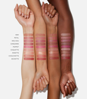 Four arms with different shades of pink lipstick swatches on a white background