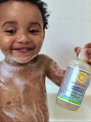 Child in a bath with a bottle of shampoo and bodywash