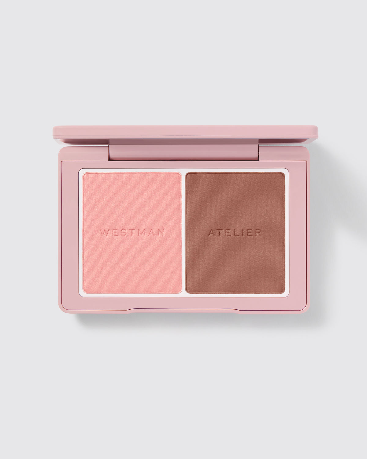A compact powder blush duo by Westman Atelier, with one shade darker and one lighter, housed in a pink case.