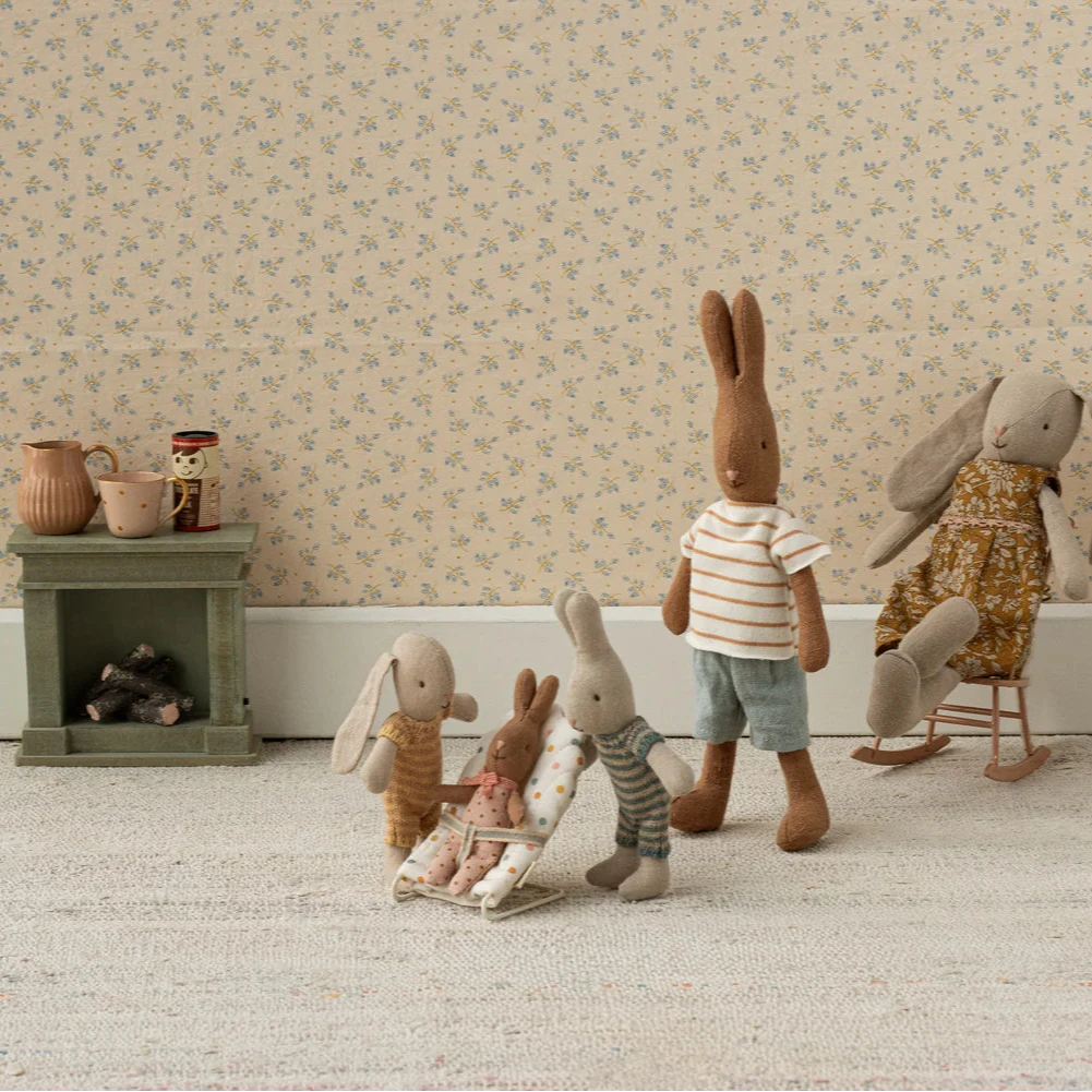 A small, multicolored dotted baby carrier with a metal frame and fabric covering, designed for toy rabbits and baby mice.