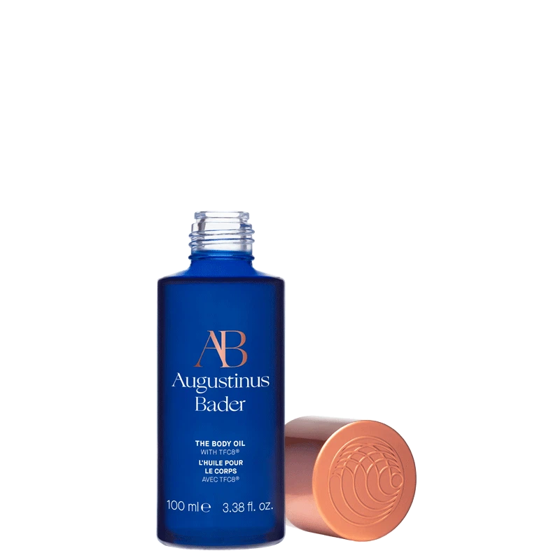 A blue bottle of the body oil with a copper cap