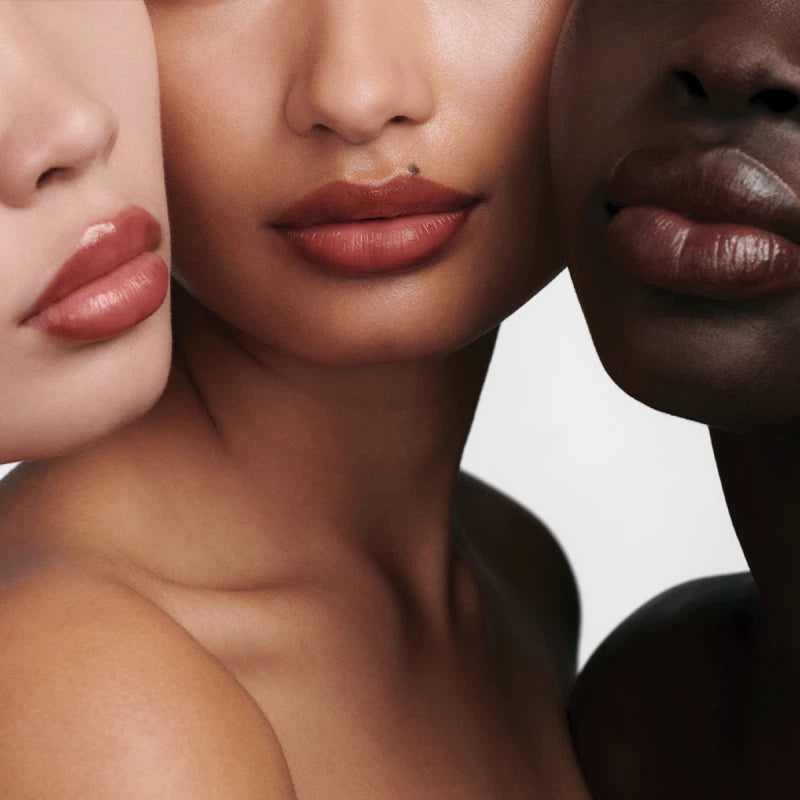 Three women with different skin tones and lip colors on a neutral background