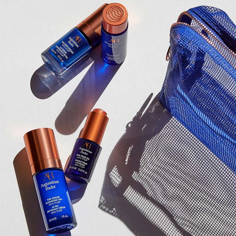 Blue and copper skincare products with a blue mesh pouch on a light gray background