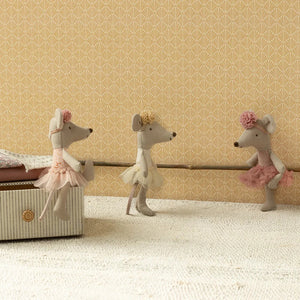 Three toy mice in ballet costumes standing next to a storage box against a patterned wall.