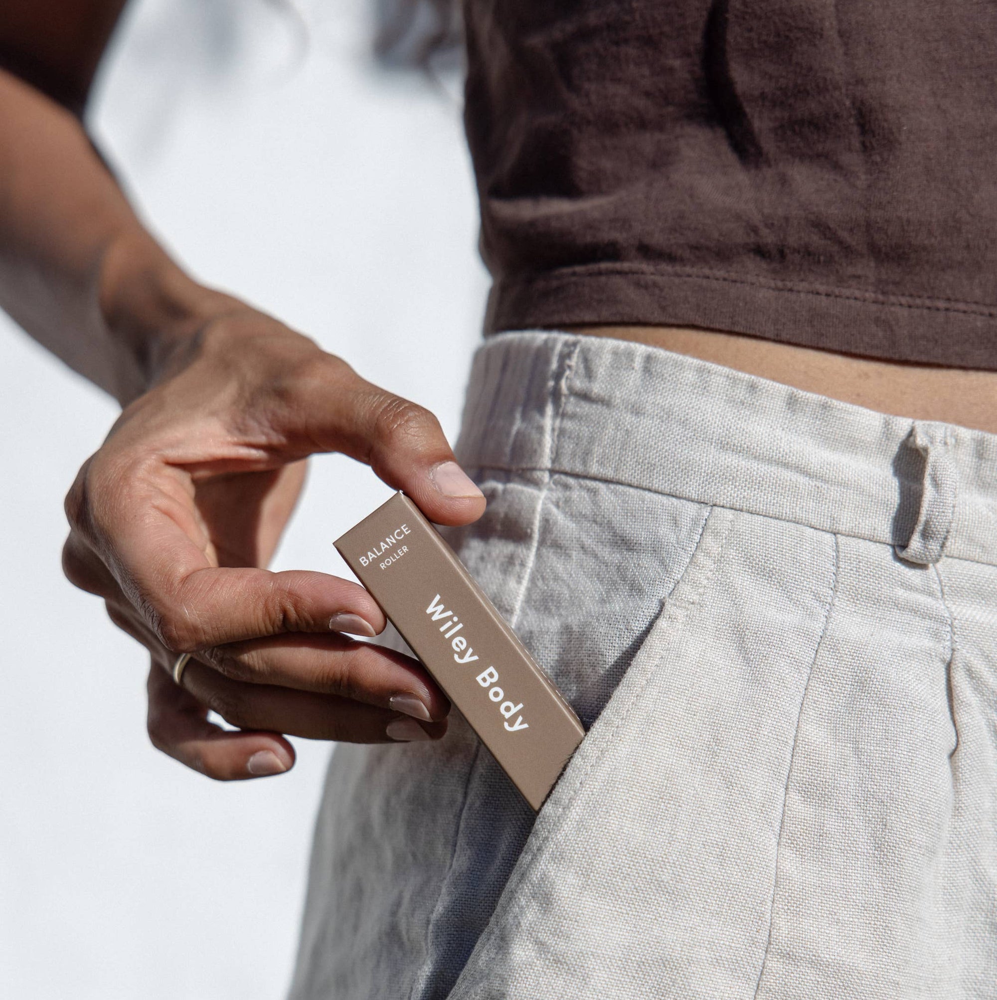 A person placing a box of Wiley Body Balance roller in her pocket. 