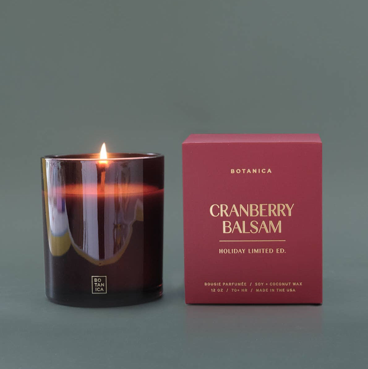 Cranberry Balsam candle and its packaging on a gray background