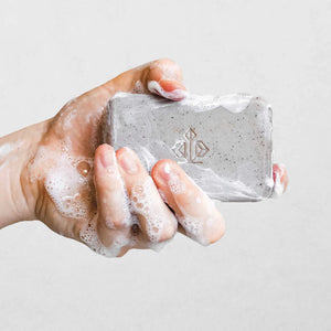 A person holding a bar of soap. 