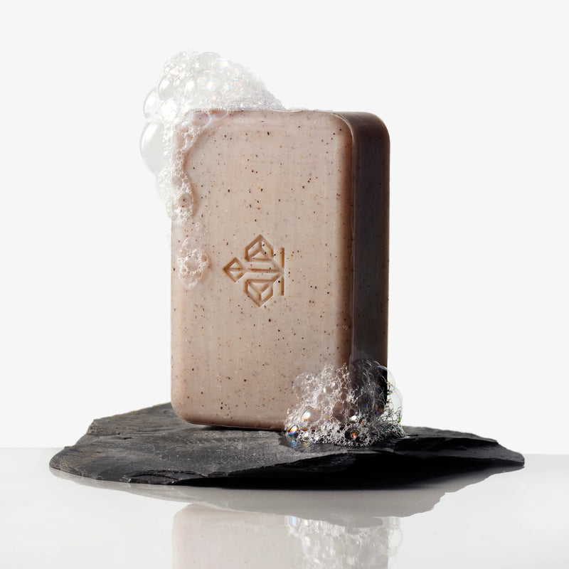 A body cleansing bar, sitting on a rock. 