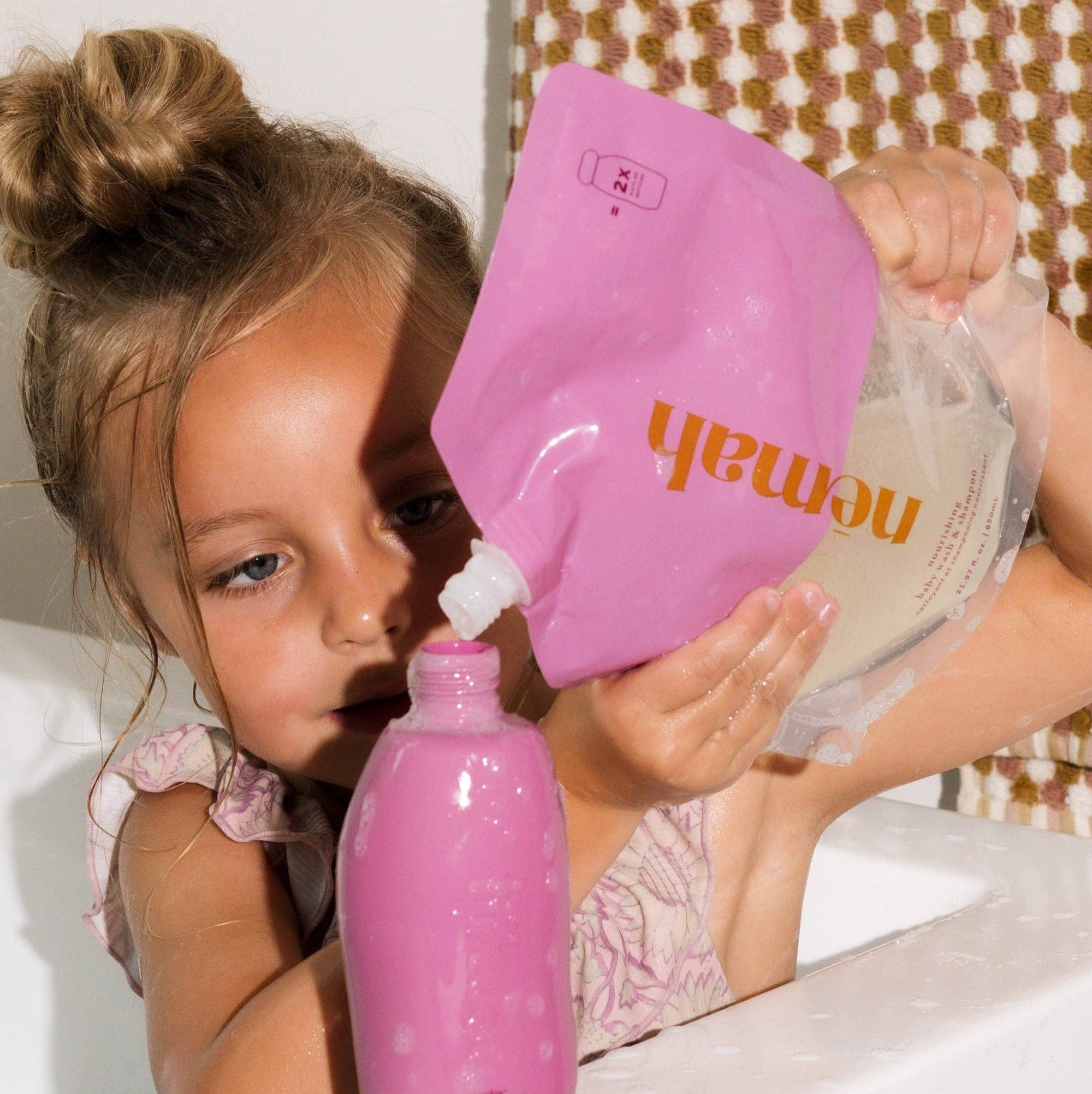 A child refilling nomad body wash and shampoo bottle. 
