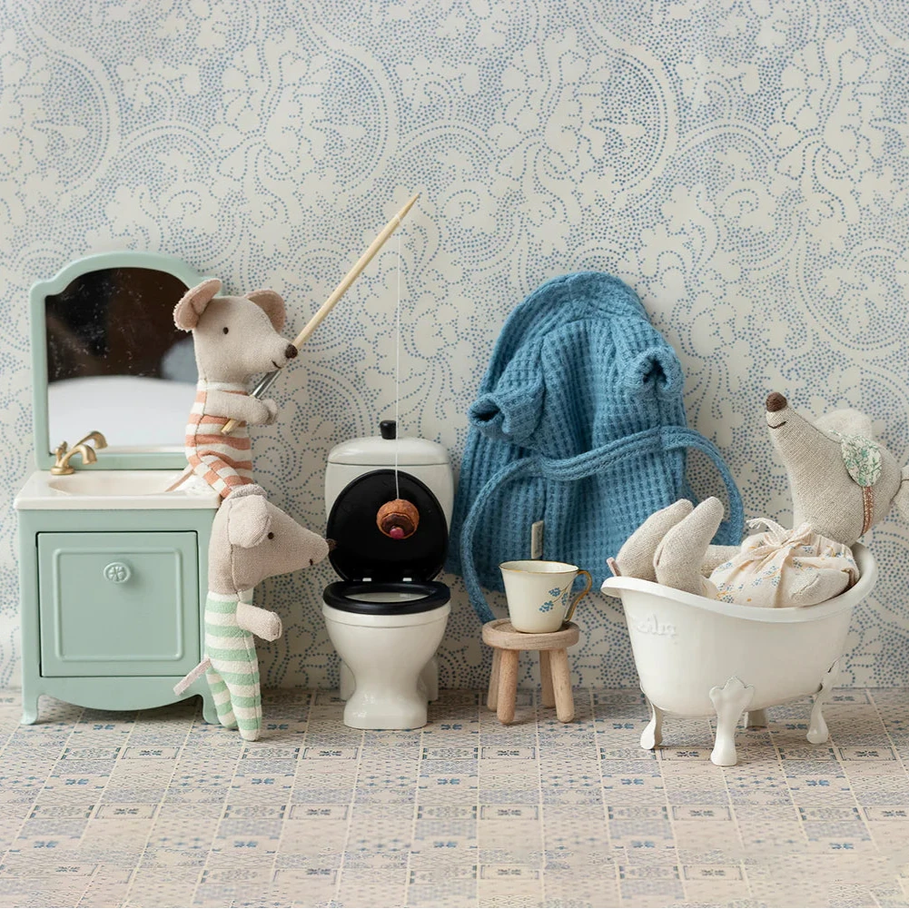 A small, white, metal mouse bathtub with four legs designed for toy mice.