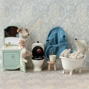 Toy animals in a bathroom setting with sink, toilet, and bathtub.