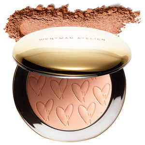 Compact powder with heart patterns and a gold lid, featuring Westman Atelier branding.